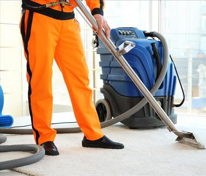 Image of a person cleaning a carpet with a vaccum