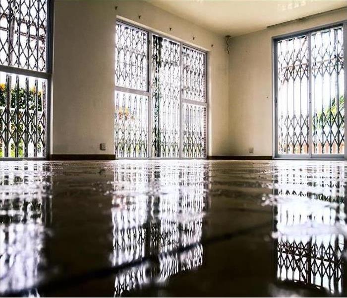 Image of a room in a commercial building with flooded floors. 