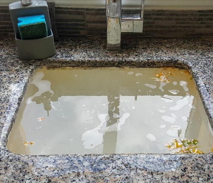 Image of a flooded sink due to a clogged drain