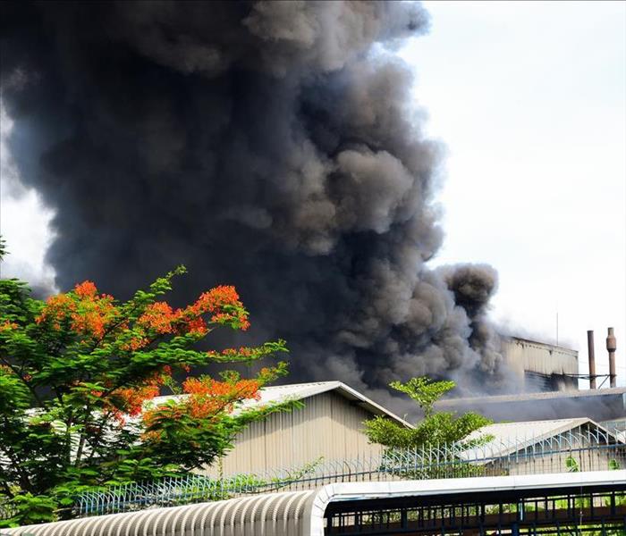 Image of black smoke coming out a building on fire. 