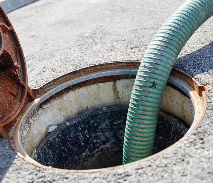 Image of a hose going into a sewer